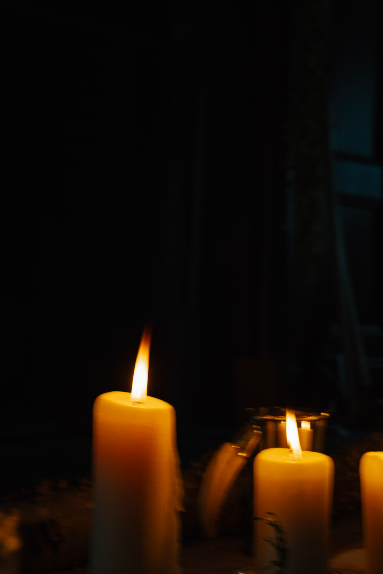 Candles burning low in a darkened room