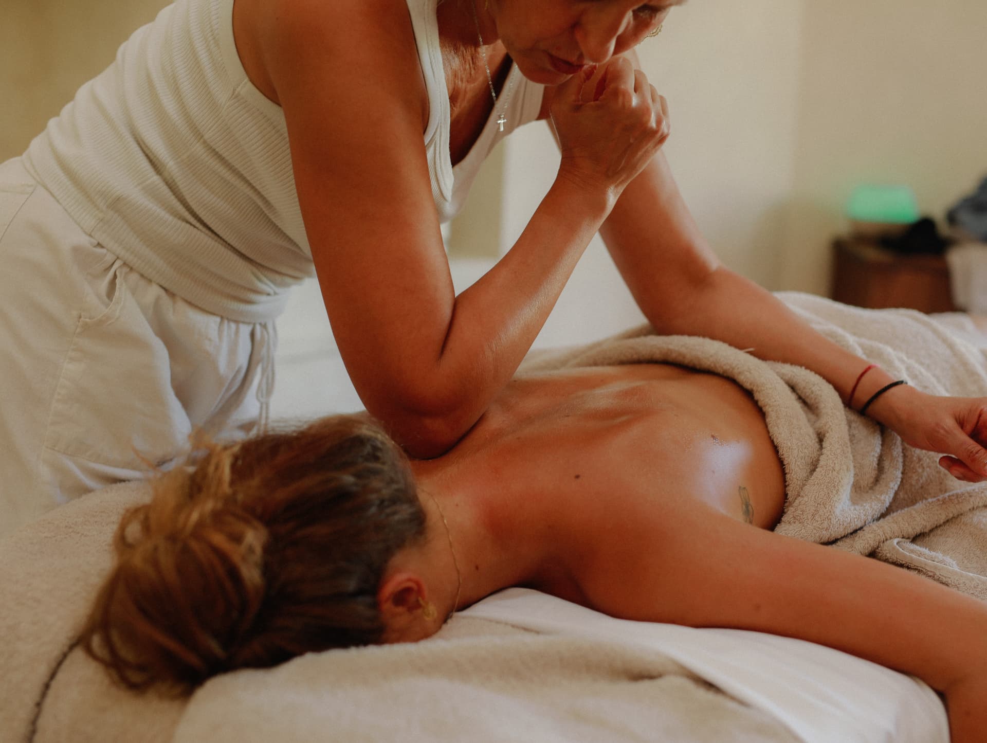 A woman receiving a massage on a table in soft light