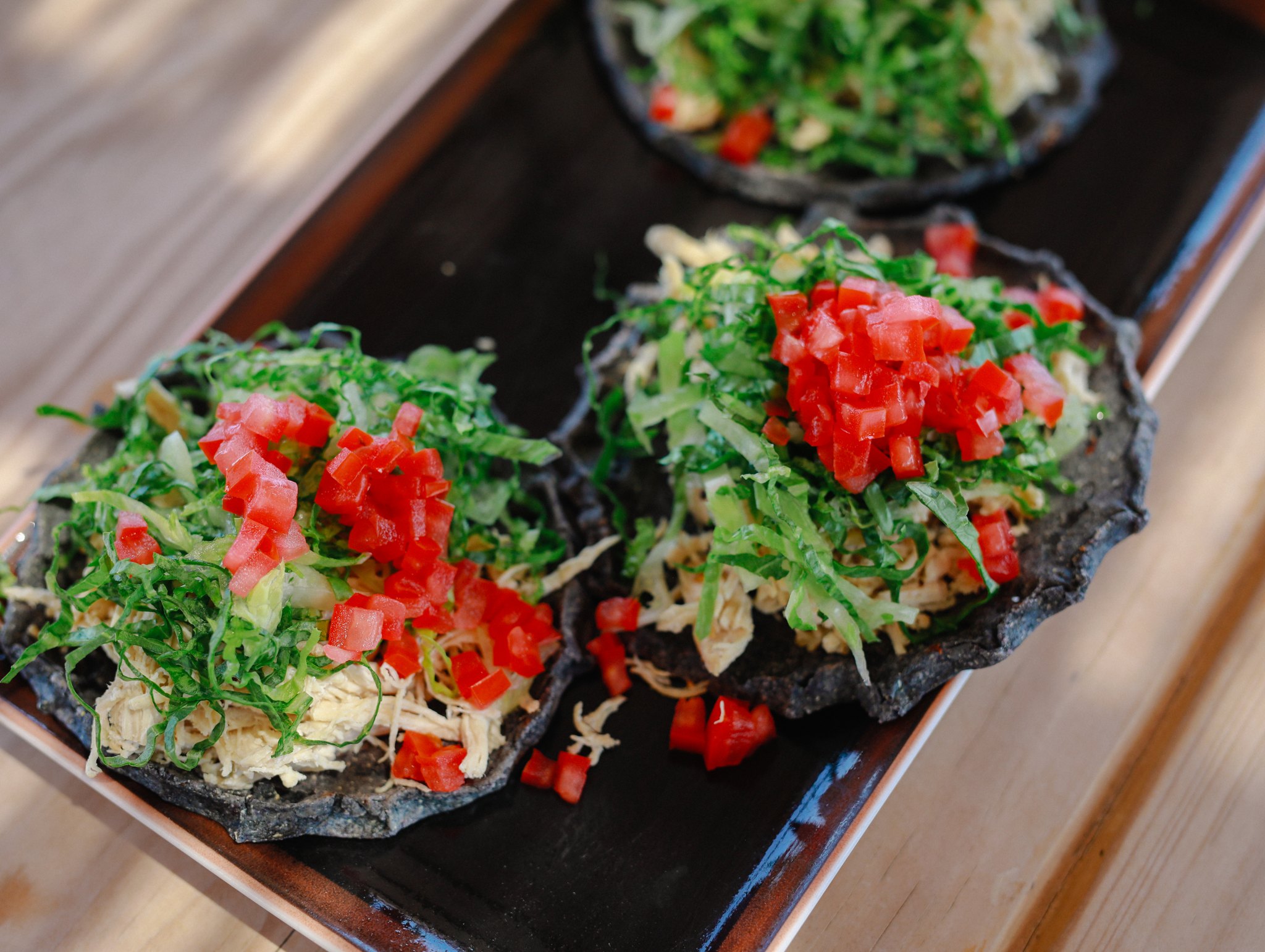 Overhead view of colorful salads on dark platters
