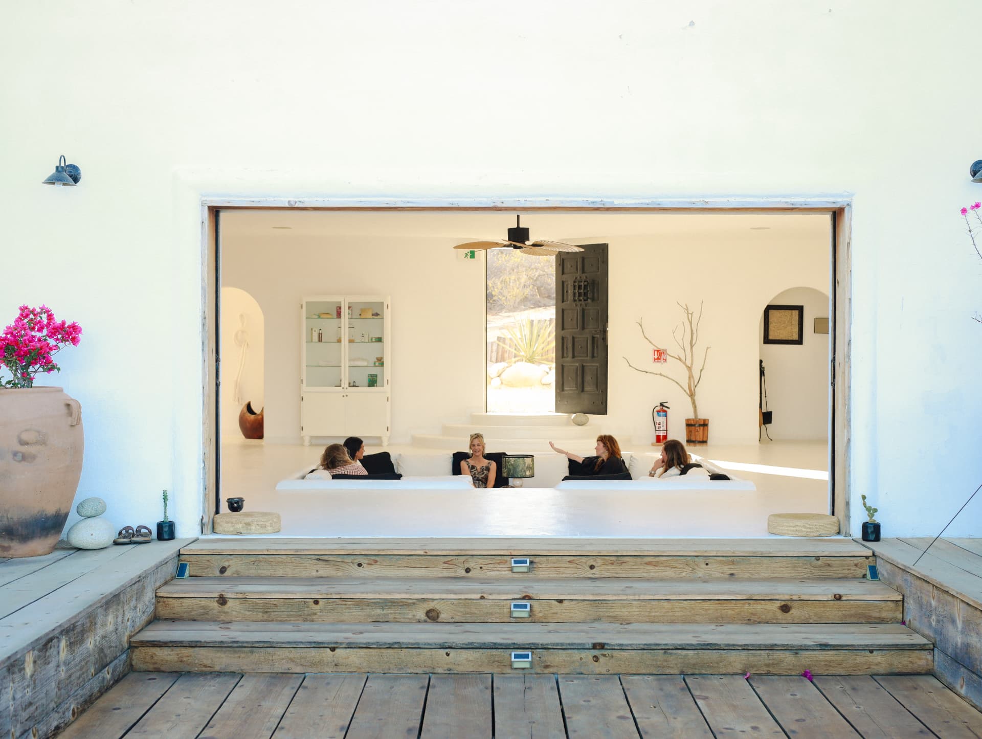 Steps leading from the wooden deck into an open room with women gathered inside