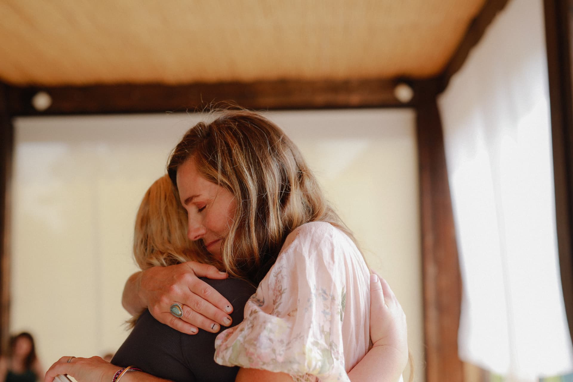 Lindsay embracing a woman at the Italy gathering