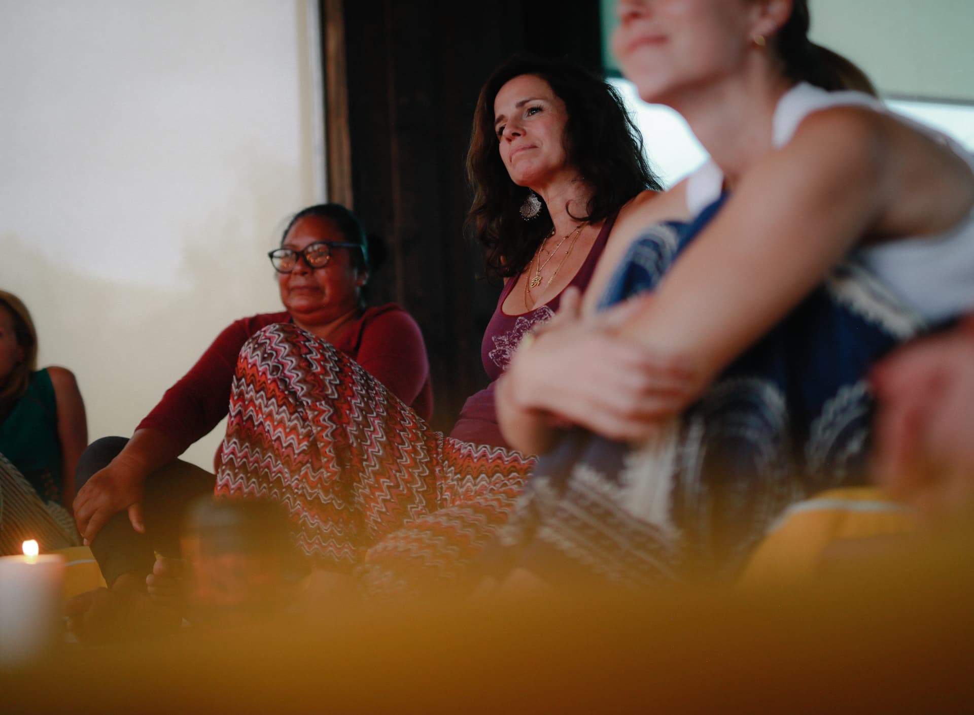 Women seated together in a candlelit circle