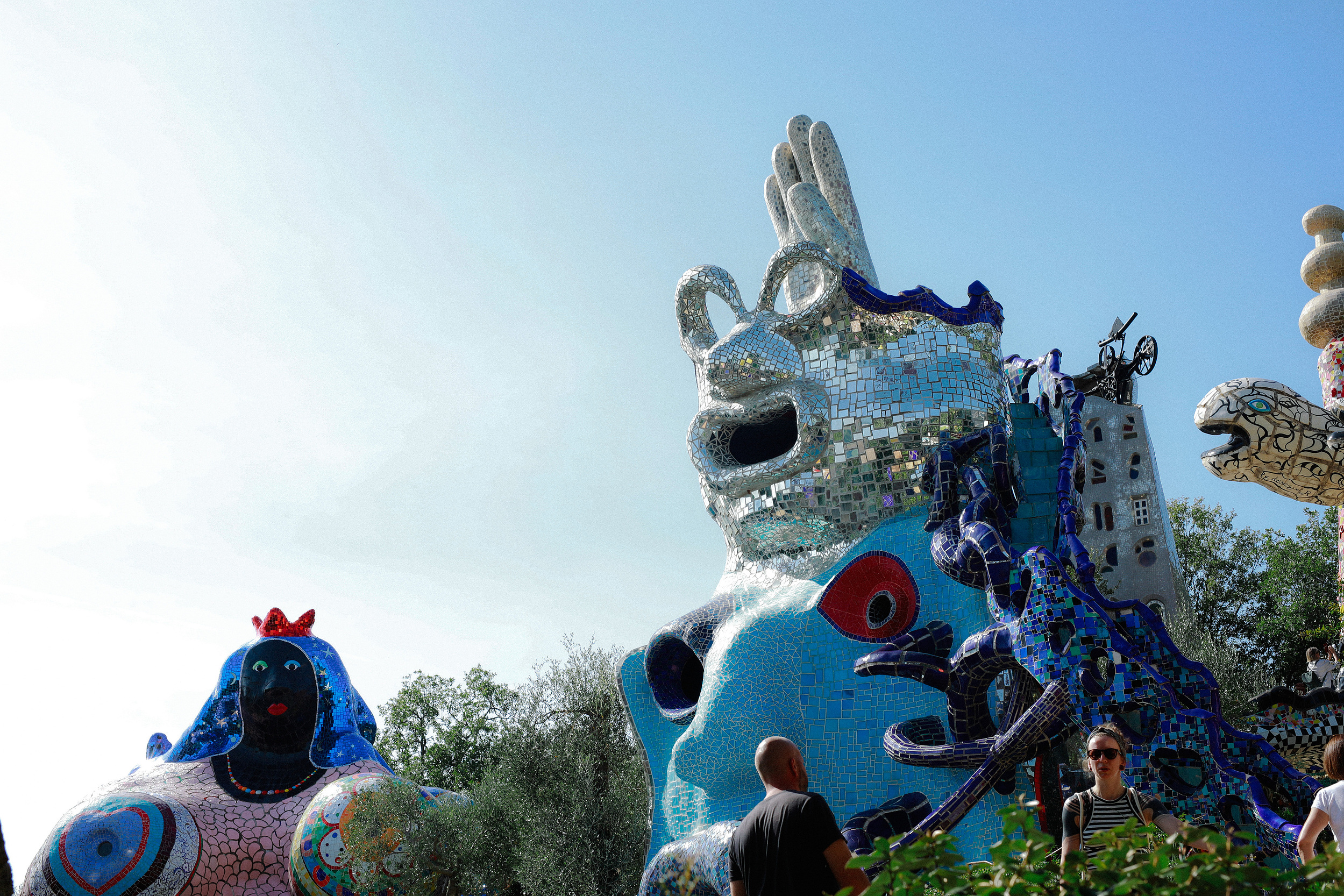 A vivid mosaic figure rising against blue sky at Niki de Saint Phalle’s Tarot Garden