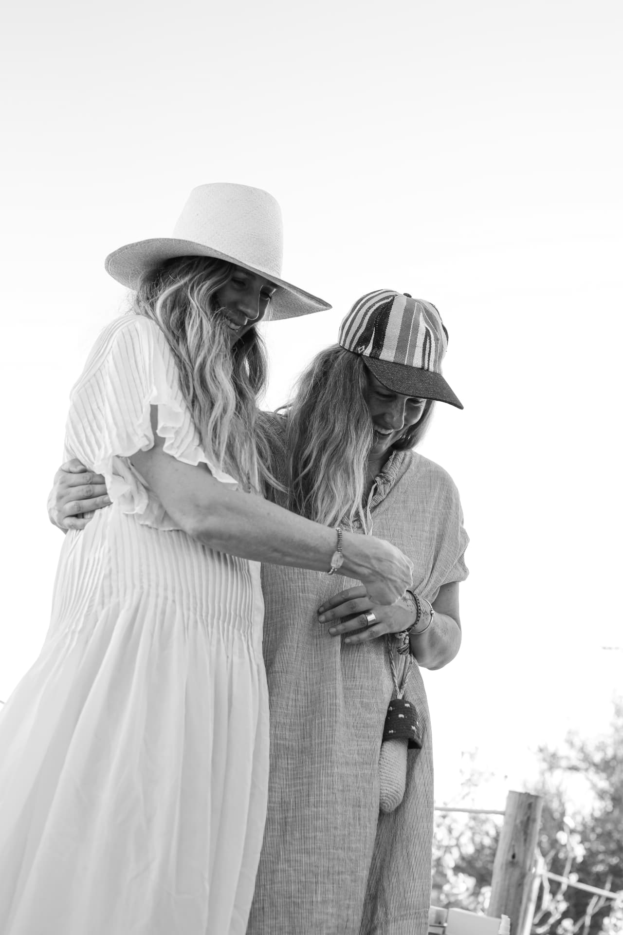 Two women leaning into one another, in black and white