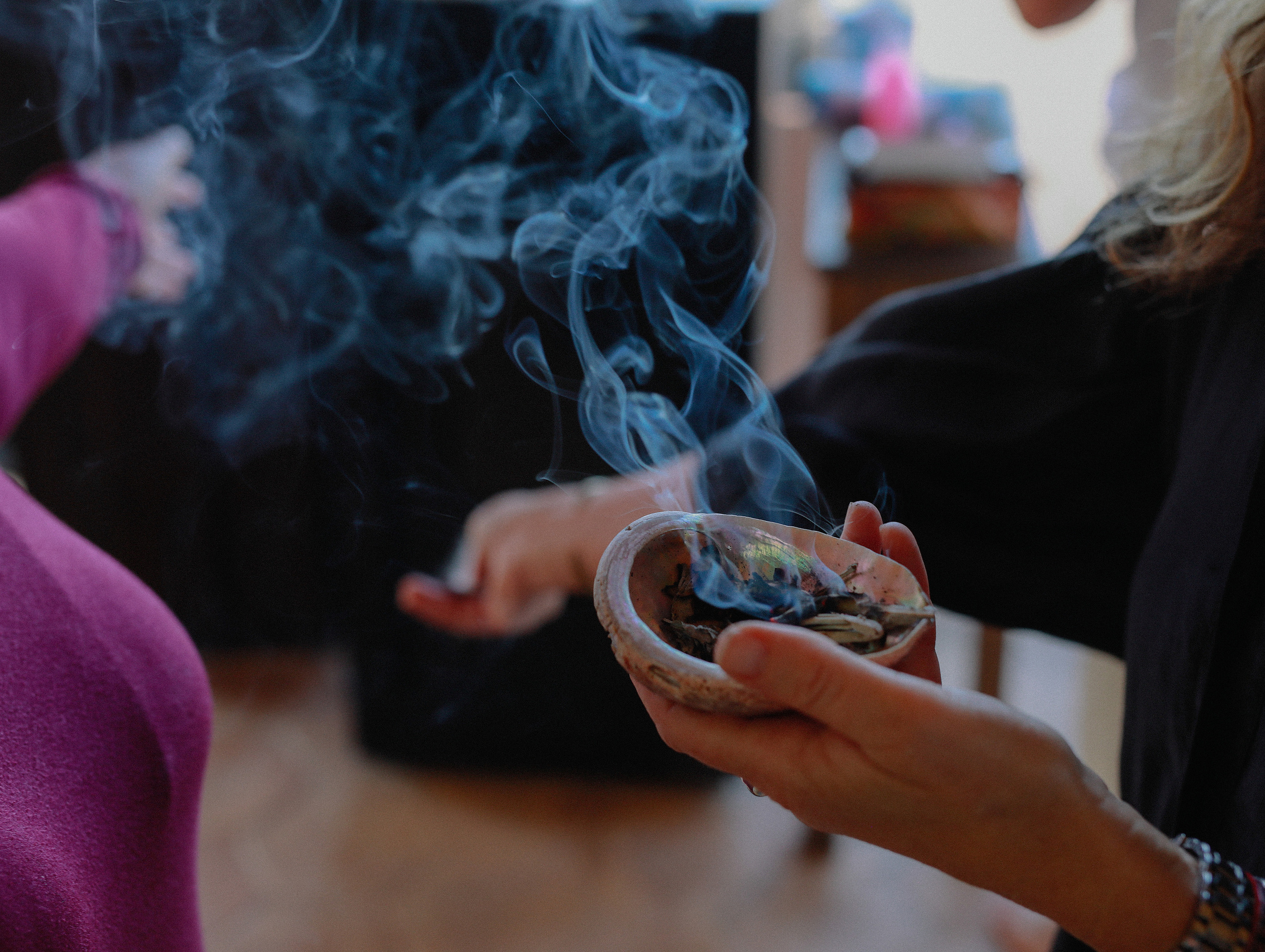 Hands holding a smoking bowl during ritual
