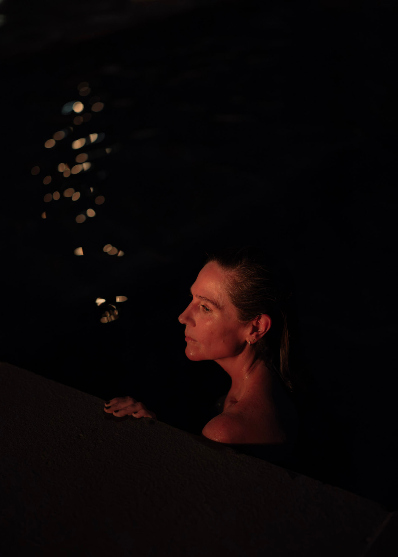 A woman in profile in the quiet darkness of the sauna