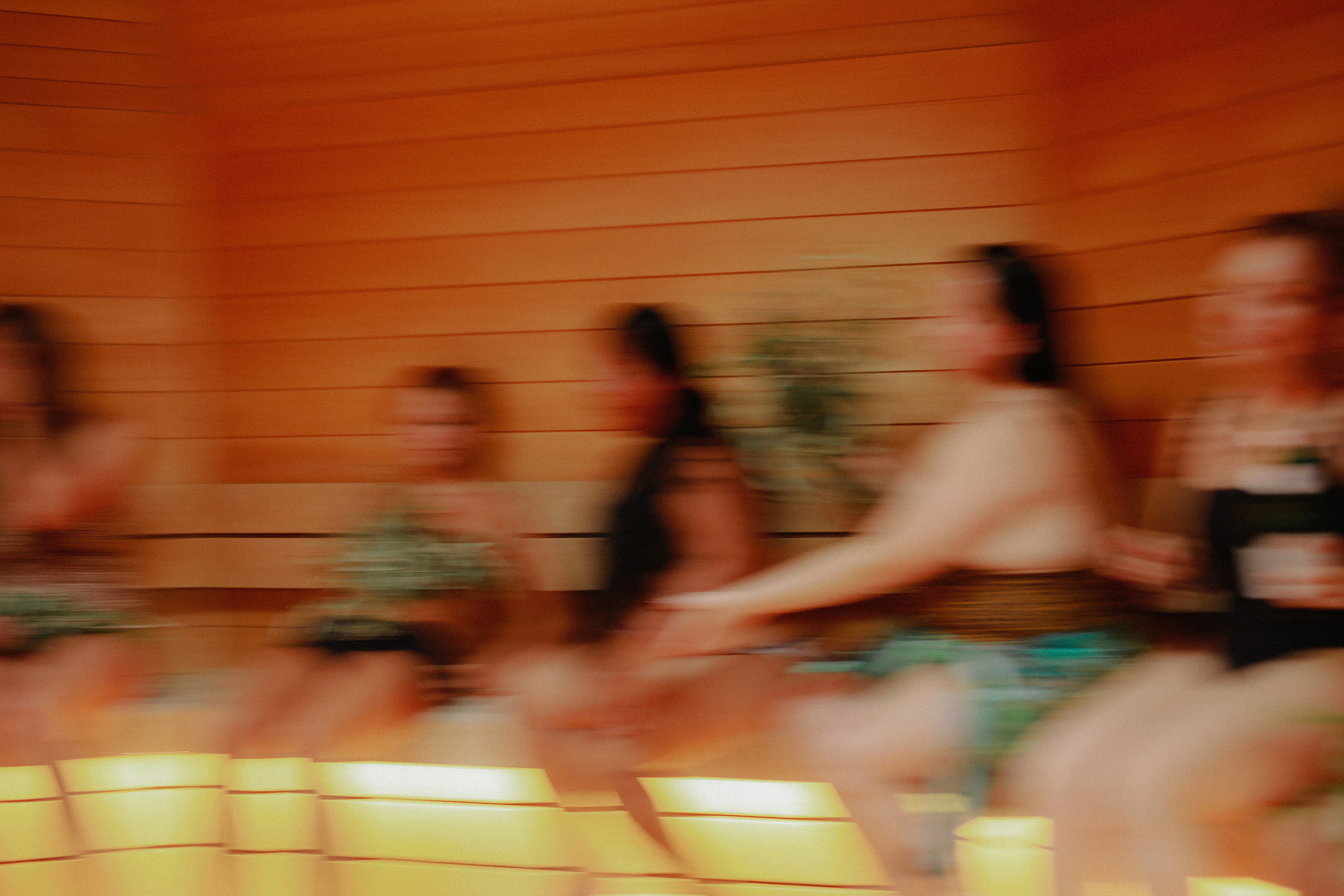 Women moving in the golden warmth of the sauna