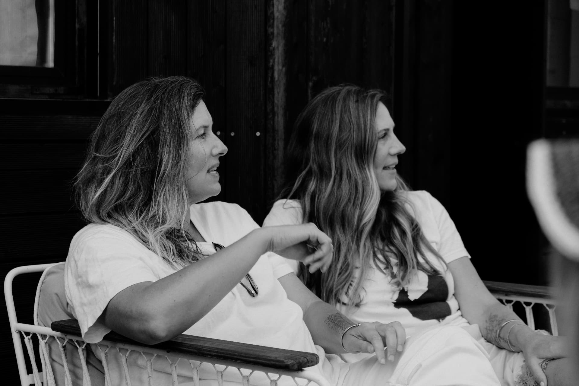 Two women talking side by side, in black and white