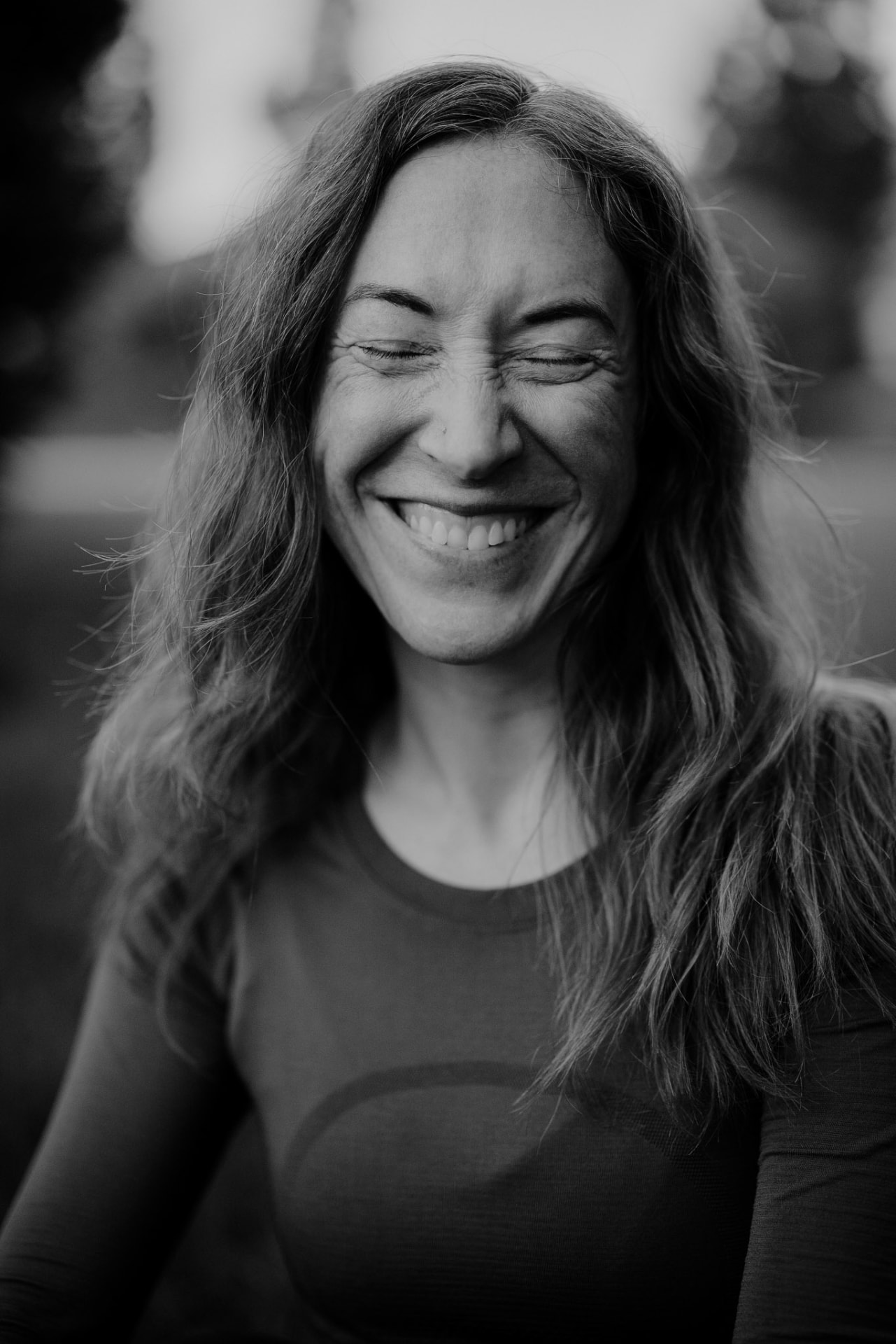 Black-and-white portrait of a woman smiling with her eyes closed