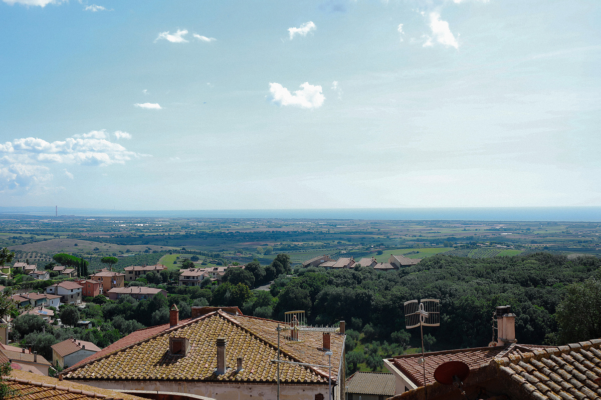 Terracotta rooftops and green countryside stretching to the sea